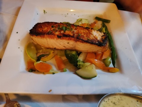 Grilled Salmon and vegetables with creamy pesto sauce at Alaine's Osteria in Palmetto Bay