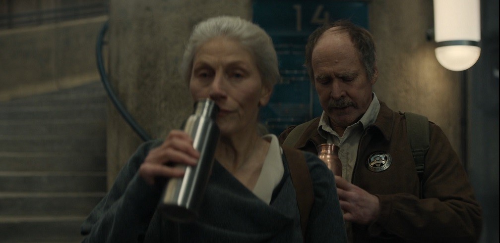 Mayor Ruth Jahns and Deputy Marnes drinking water on their way down the silo stairs in Silo Season 1 Episode 3