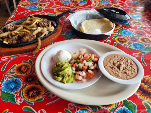 Steak Fajitas with guacamole, sour cream, pico de gallo,  frijoles a la charra and 4 corn tortillas at Casita Tejas in Homestead