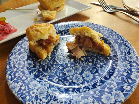 One bite into the Root and Bone Chicken Biscuits at South Miami, created with chicken jus and benne seeds and honey butter. Served with homemade pickles and tobasco pepper jelly.